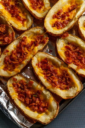 Stuffed baked potato skins with cheddar cheese and bacon crumblesの写真素材