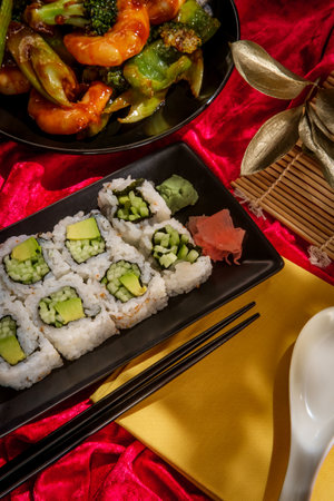 Chinese cuisine szechuan shrimp with vegetables and cucumber avocado sushi rollの写真素材