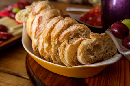 Crusty Italian bread with charcuterie board in backgroundの写真素材