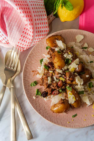 Greek shredded lamb stew marinated in a white wine salmoriglio sauce with new potatoes kalamata olives feta cheese and mint garnishの写真素材