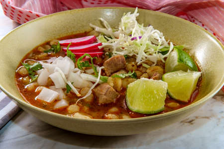 Mexican Pozole rojo pork and hominy stew with variety of fresh vegetable toppings to garnishの写真素材