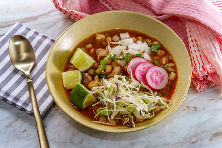 Mexican Pozole rojo pork and hominy stew with variety of fresh vegetable toppings to garnishの写真素材