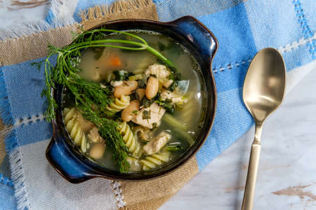 Chicken noodle soup with cannellini beans and spinachの写真素材