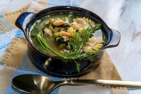 Chicken noodle soup with cannellini beans and spinachの写真素材