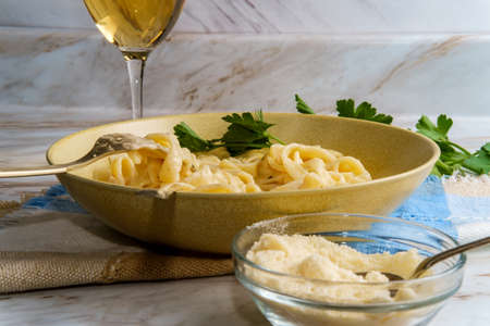 Italian fettuccine alfredo with glass of white wine and parmesan cheese