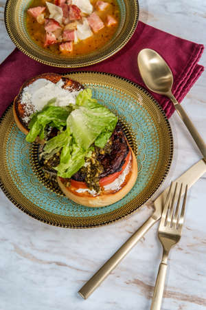 Portobello mushroom burger with pesto and goat cheese and side slow-cooker ham and cannellini bean...