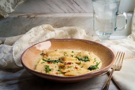 Cheese ravioli in a Tuscan creamy sauce with spinach and crushed red pepperの写真素材