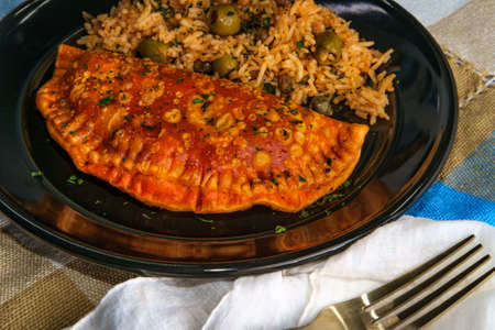 Mexican fried empanada meat pies with olive caper riceの写真素材