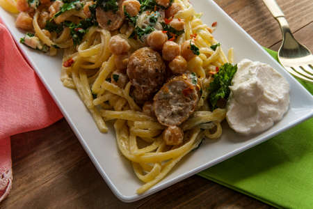 Linguine pasta with Italian chicken sausage chickpeas and kale in a creamy ricotta cheese sauceの写真素材