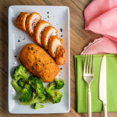Chicken cordon bleu served with steamed broccoliの写真素材