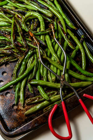 Roasted char-grilled green beans cooling in oven panの写真素材