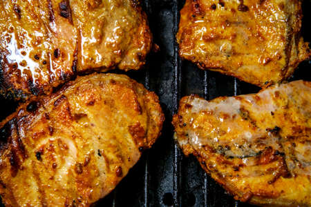 Marinated honey glaze pork chops cooking on propane grill