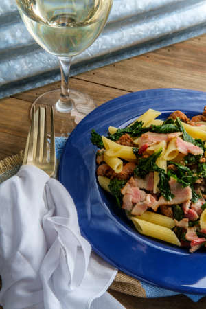 Italian bacon sausage penne pasta in a white wine garlic sause with kaleの写真素材