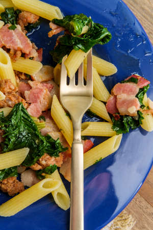 Italian bacon sausage penne pasta in a white wine garlic sause with kaleの写真素材