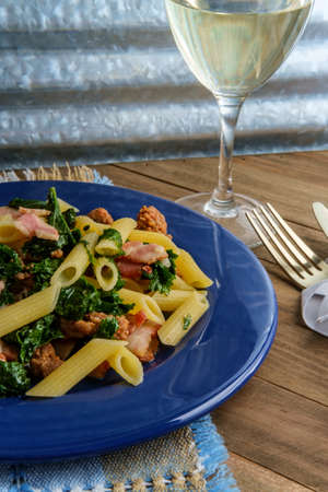 Italian bacon sausage penne pasta in a white wine garlic sause with kaleの写真素材