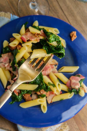 Italian bacon sausage penne pasta in a white wine garlic sause with kaleの写真素材