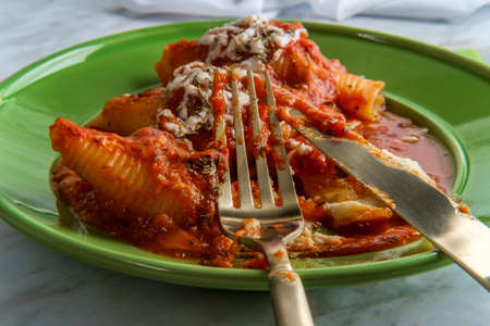 Italian stuffed conchiglioni shell pasta baked in marinara tomato sauce