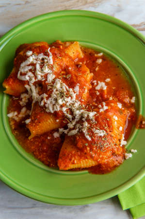 Italian stuffed conchiglioni shell pasta baked in marinara tomato sauceの写真素材