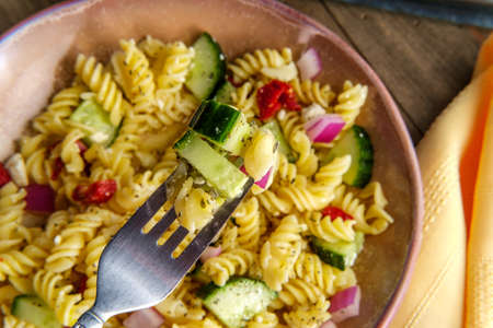 Italian vegetarian fusilli pasta salad with sundried tomatoes cucumber red onion and feta cheeseの写真素材