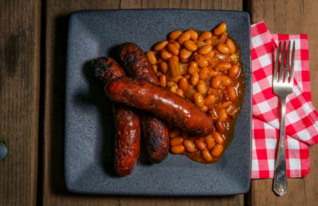 Grilled bratwurst with bacon cowboy beans on picnic tableの写真素材