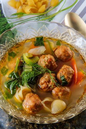 Italian wedding soup with meatballs conchiglie pasta carrots and spinachの写真素材