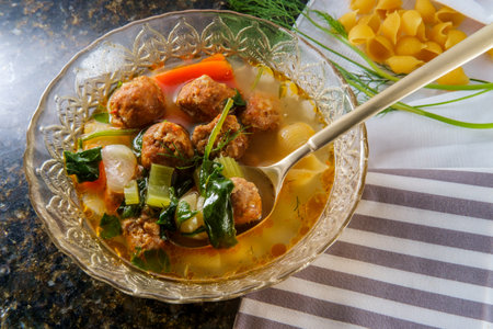 Italian wedding soup with meatballs conchiglie pasta carrots and spinachの写真素材