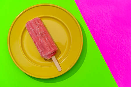 Strawberry fruity pink icepop on modern stylized neon pink background