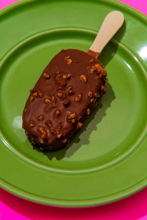 Chocolate coated icecream bar on stylized modern neon pink background