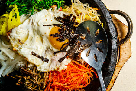 Korean hot beef bibimbap served in dolsot stone pot with banchan side dishesの写真素材