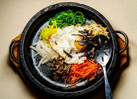 Korean hot beef bibimbap served in dolsot stone pot with banchan side dishesの写真素材
