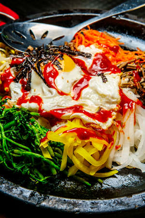 Korean hot beef bibimbap served in dolsot stone pot with banchan side dishesの写真素材