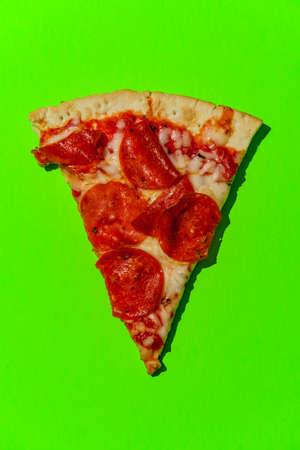 New York style pizza slices on neon colorful background shot with hard lightの写真素材