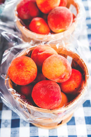 Baskets of colorful organic peaches at local farmers market