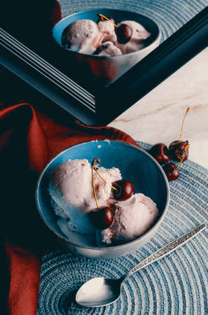 Bowl of delicious black cherry icecream on marble kitchen counter