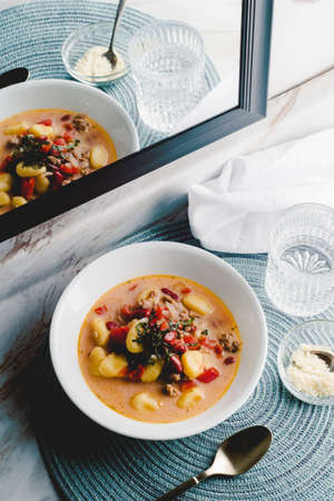 Italian cuisine sausage gnocchi soup with tomato basil brothの写真素材