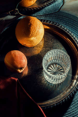 Fruit still life orange and peach with fancy drinking glass