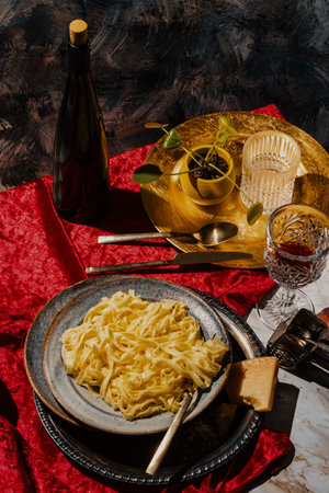 Italian fettuccine alfredo pasta with glass of red wine and parmesan cheeseの写真素材