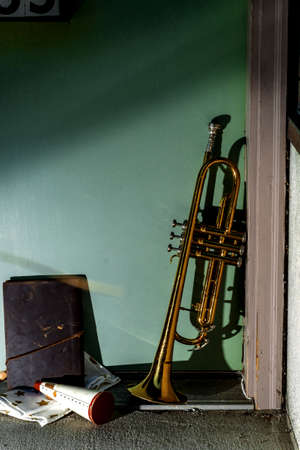 Summer jazz instrument trumpet standing alone against green front doorの写真素材