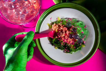 Science fiction green alien from outer space eating dinner at a fancy neon nightclub