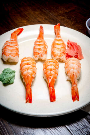 Japanese shrimp nigiri sushi with wasabi and pickled ginger in dark moddy lightingの写真素材