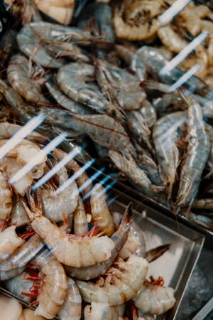 Fresh raw shell-on unpeeled shrimp chilling on iceの写真素材