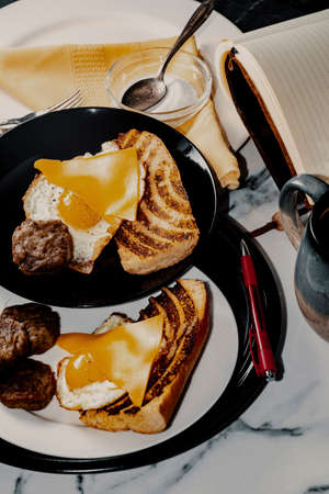 Authorâ€™s notebook and pen at kitchen table for fancy sausage egg and cheese breakfast...
