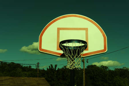 Vintage retro stylized urban basketball hoop against a blue sky