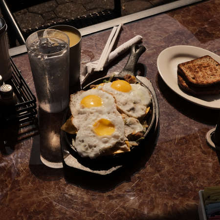 Sausage and eggs breakfast skillet with toast and orange juiceの写真素材
