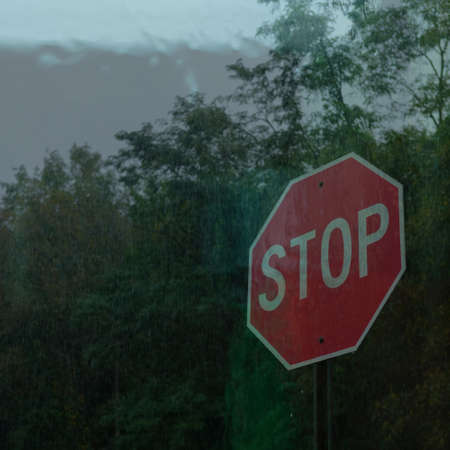 Grainy retro driving on a rainy day stop sign double exposureの写真素材