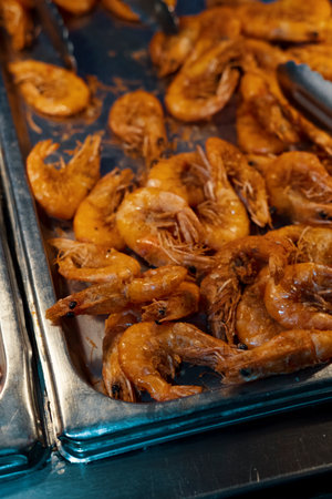 Large pile of fried whole head-on shrimp in buffet trayの写真素材