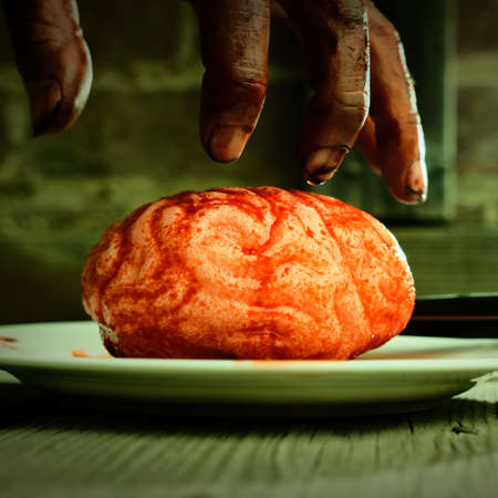 Bloody zombie hand reaching for fresh brains to eat for dinner