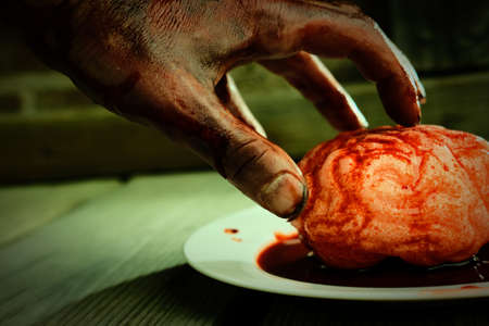 Bloody zombie hand reaching for fresh brains to eat for dinner