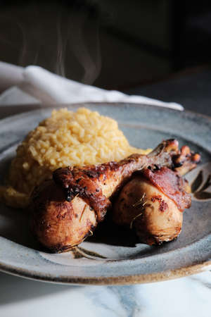 Peruvian dinner pollo a la brasa chicken legs with Aji Amarillo rice risottoの写真素材