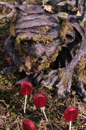 Fairytale tree person craves red lollipos from the garden as metaphor